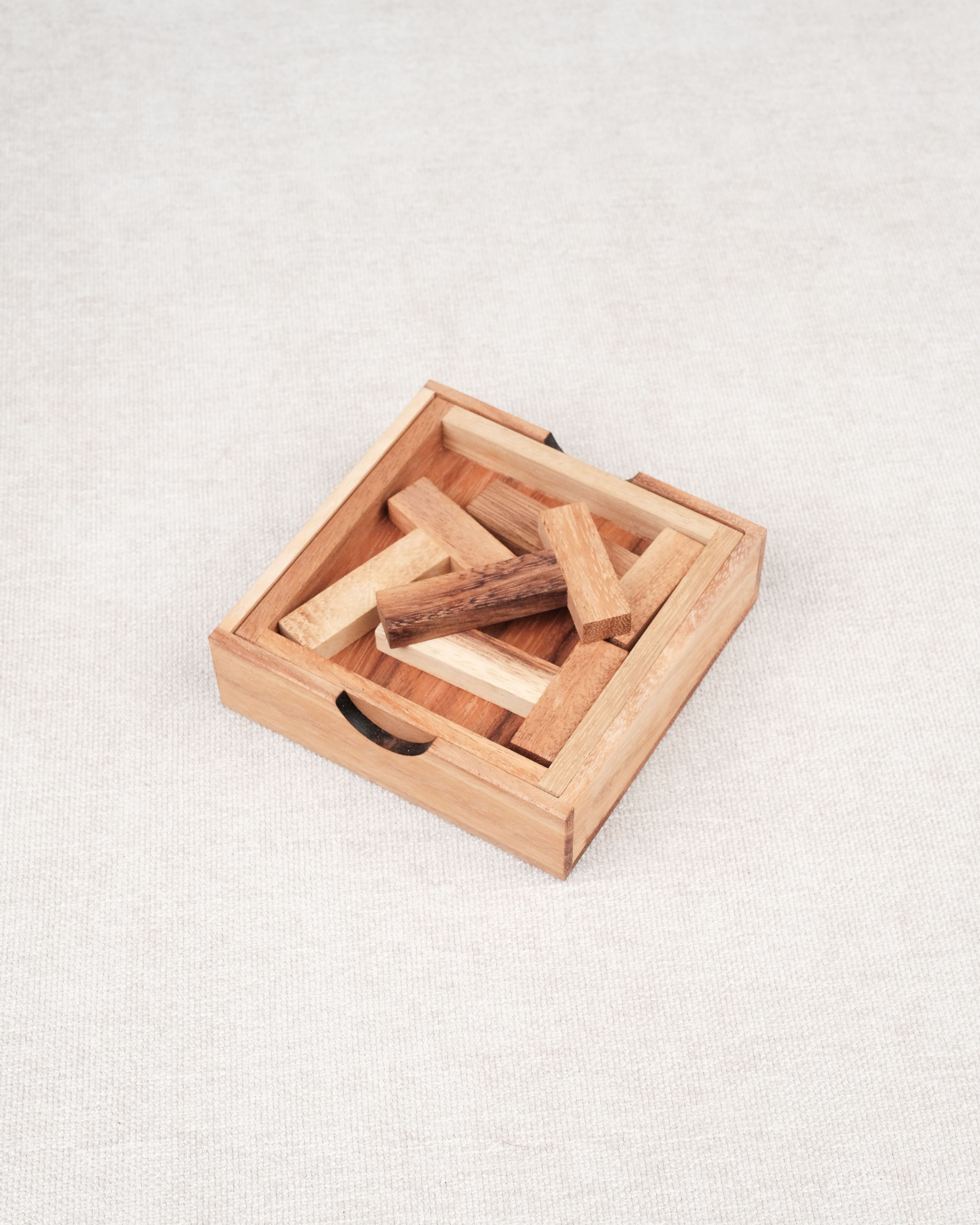 Coffret en bois contenant le casse-tête Les 4 T avec ses pièces rangées