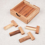 Pièces du casse-tête Les 4 T disposées à côté du coffret en bois