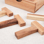 Gros plan sur les pièces en bois clair et foncé du casse-tête Les 4 T