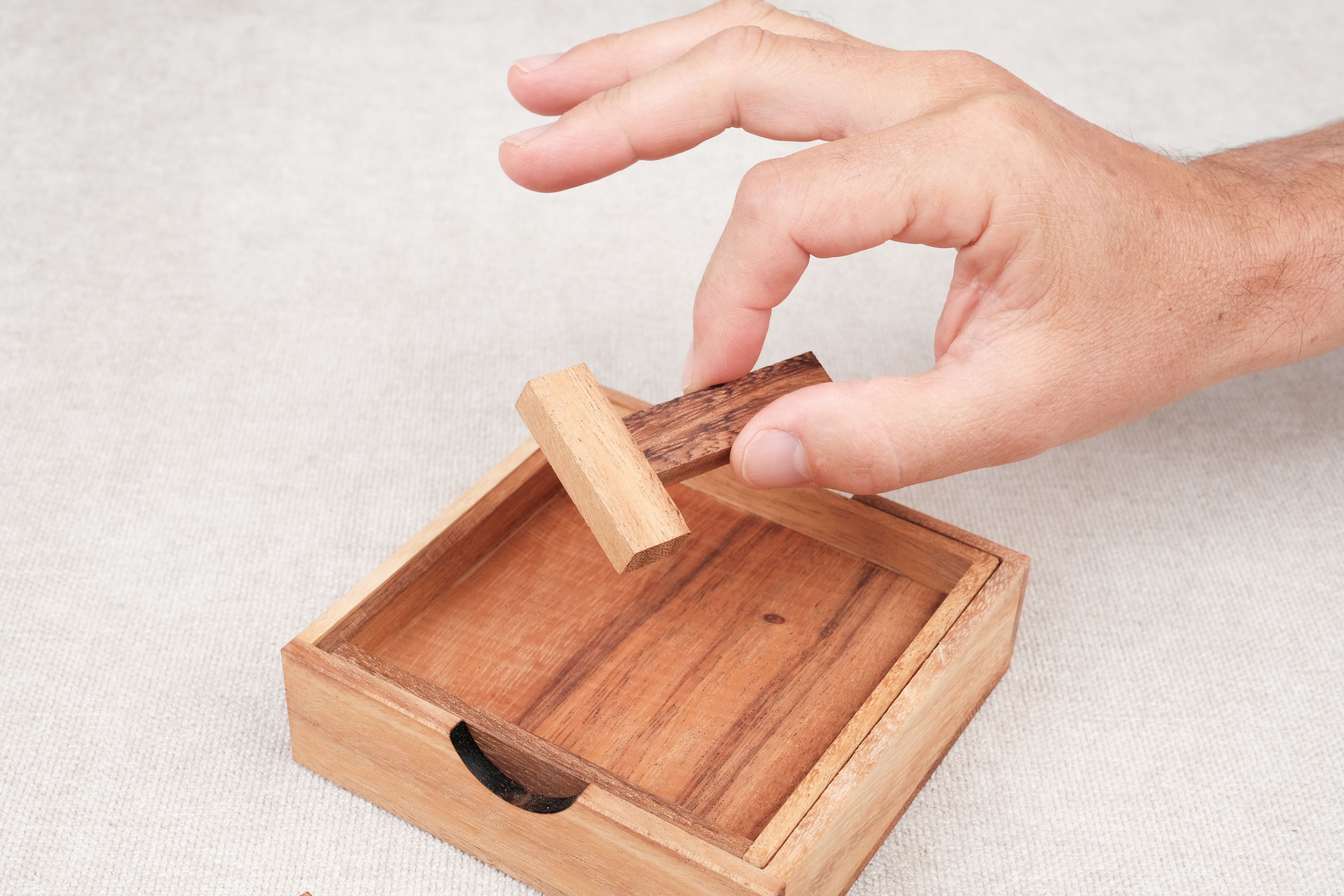 Main d’un joueur manipulant une pièce du casse-tête Les 4 T