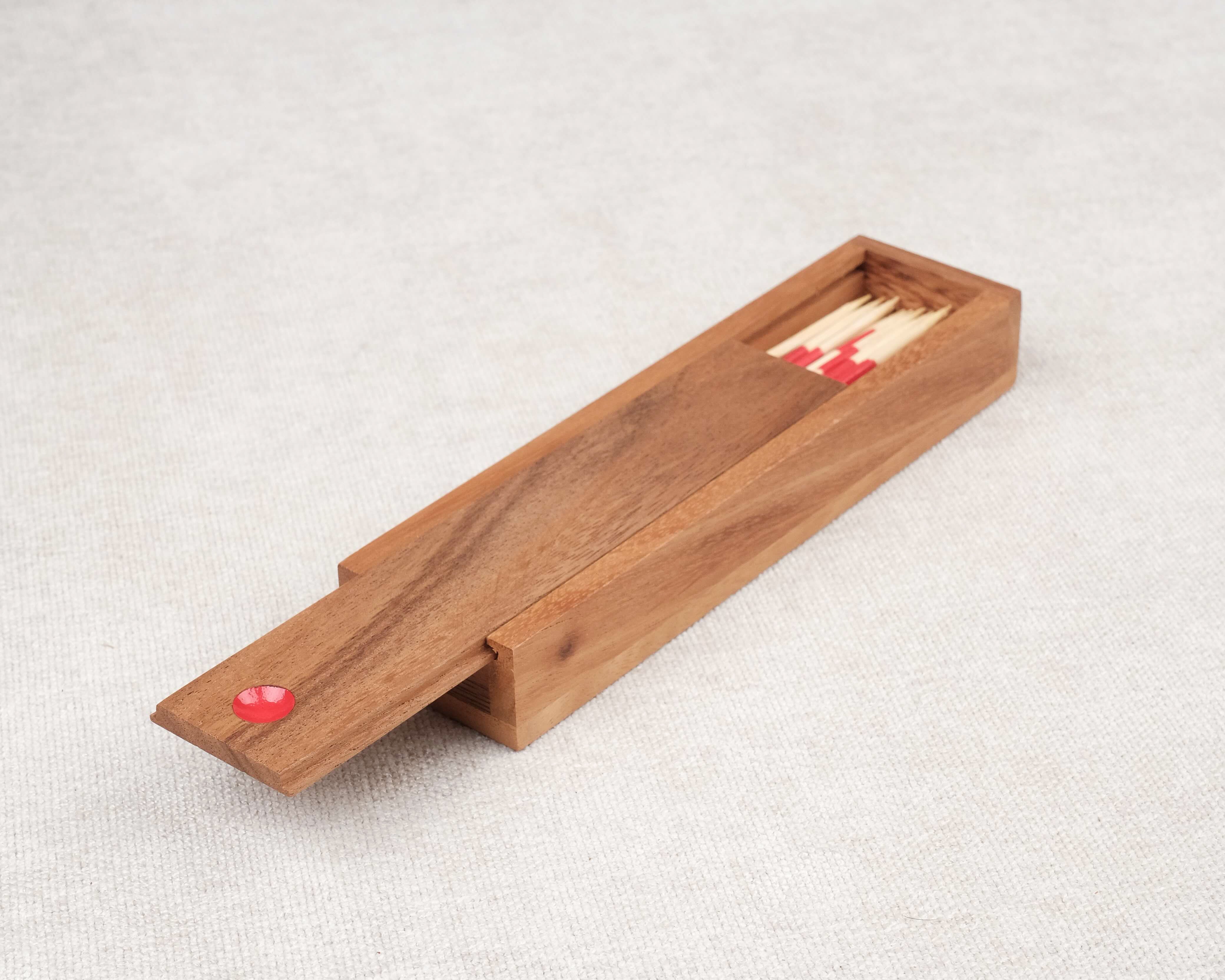 Coffret ouvert de Mikado en bois avec baguettes multicolores.