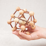 Casse-tête Molécule tenu en main, puzzle en bois à démonter et remonter.