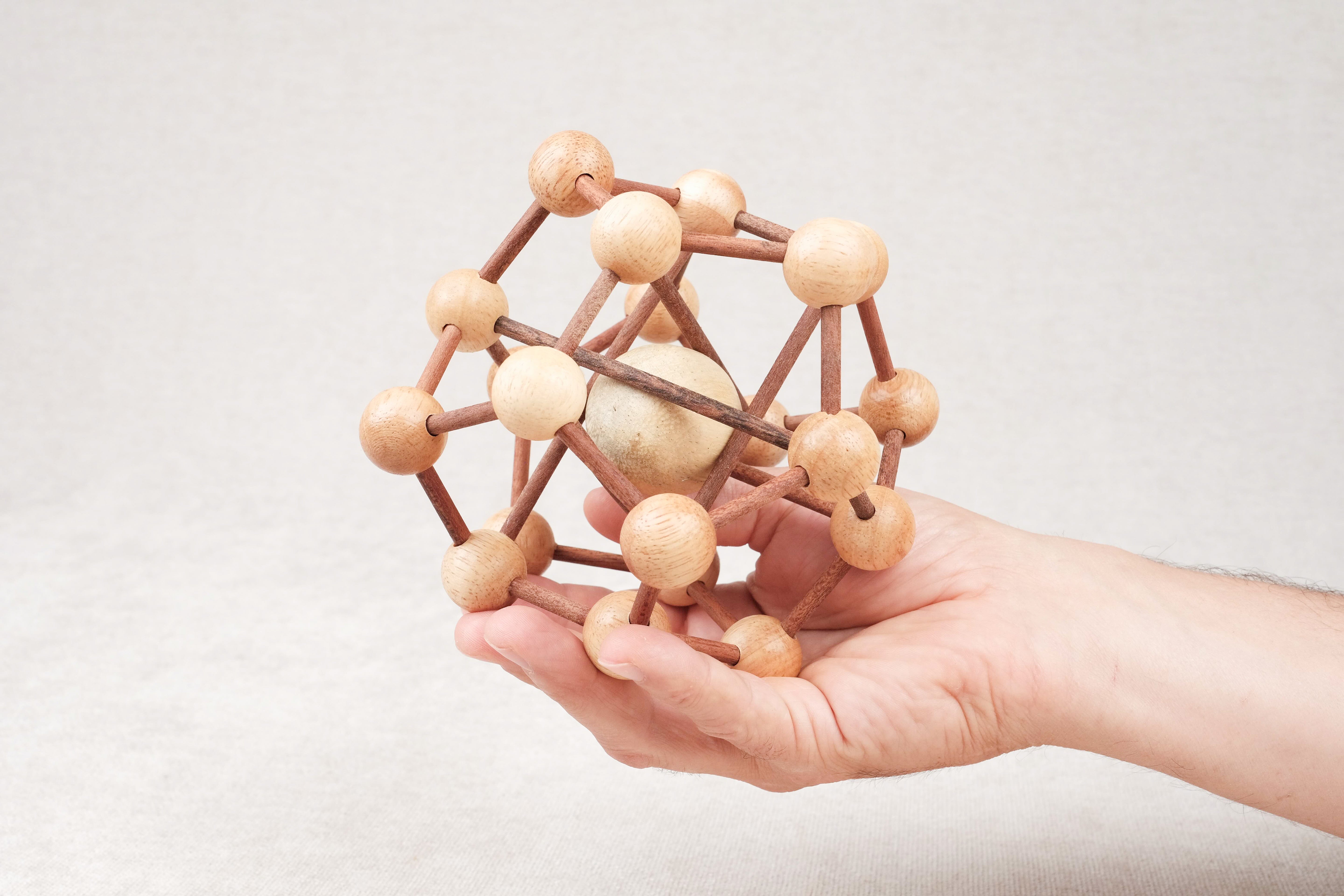 Casse-tête Molécule tenu en main, puzzle en bois à démonter et remonter.
