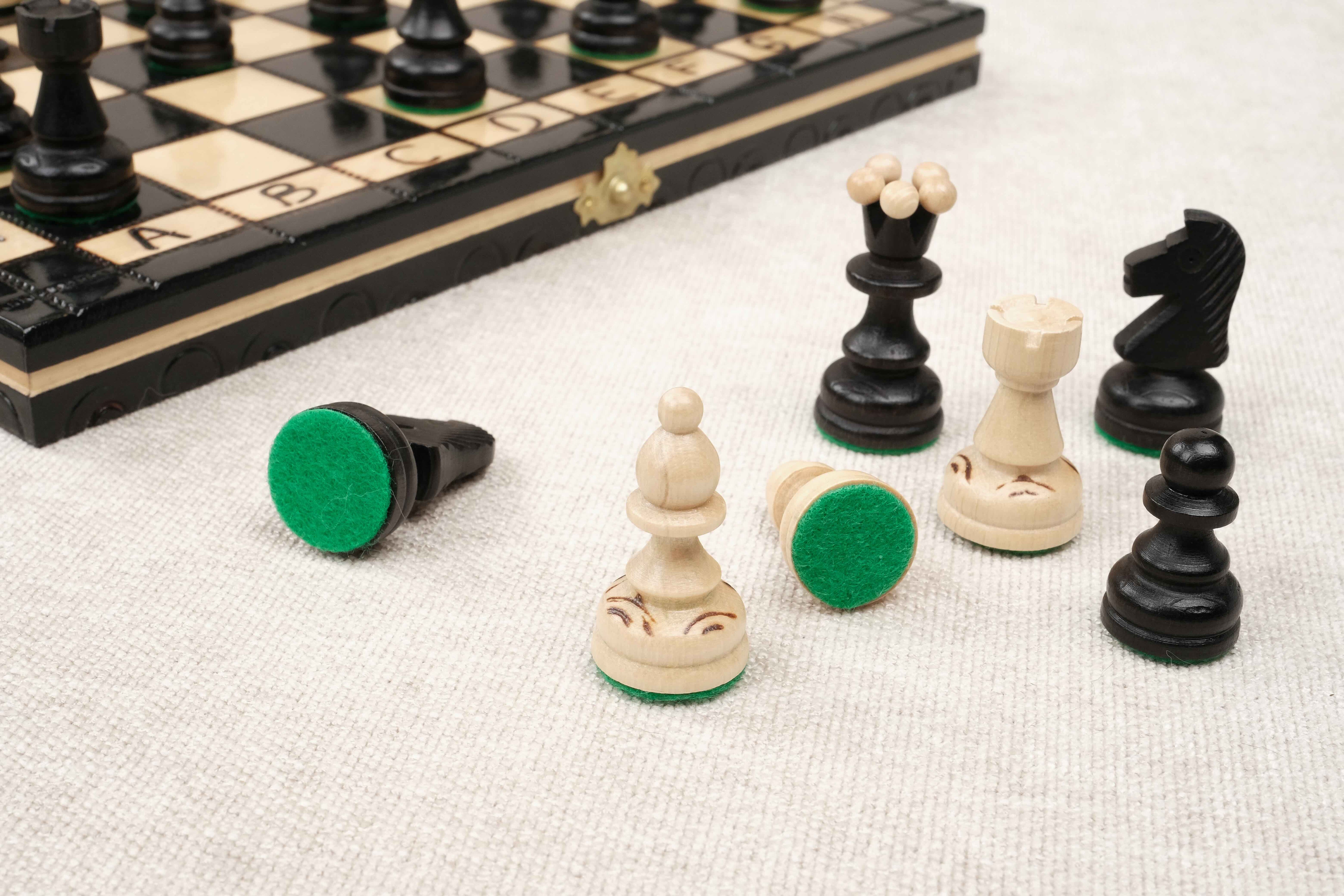 Pièces d’échecs noires et naturelles sculptées en bois avec feutrine