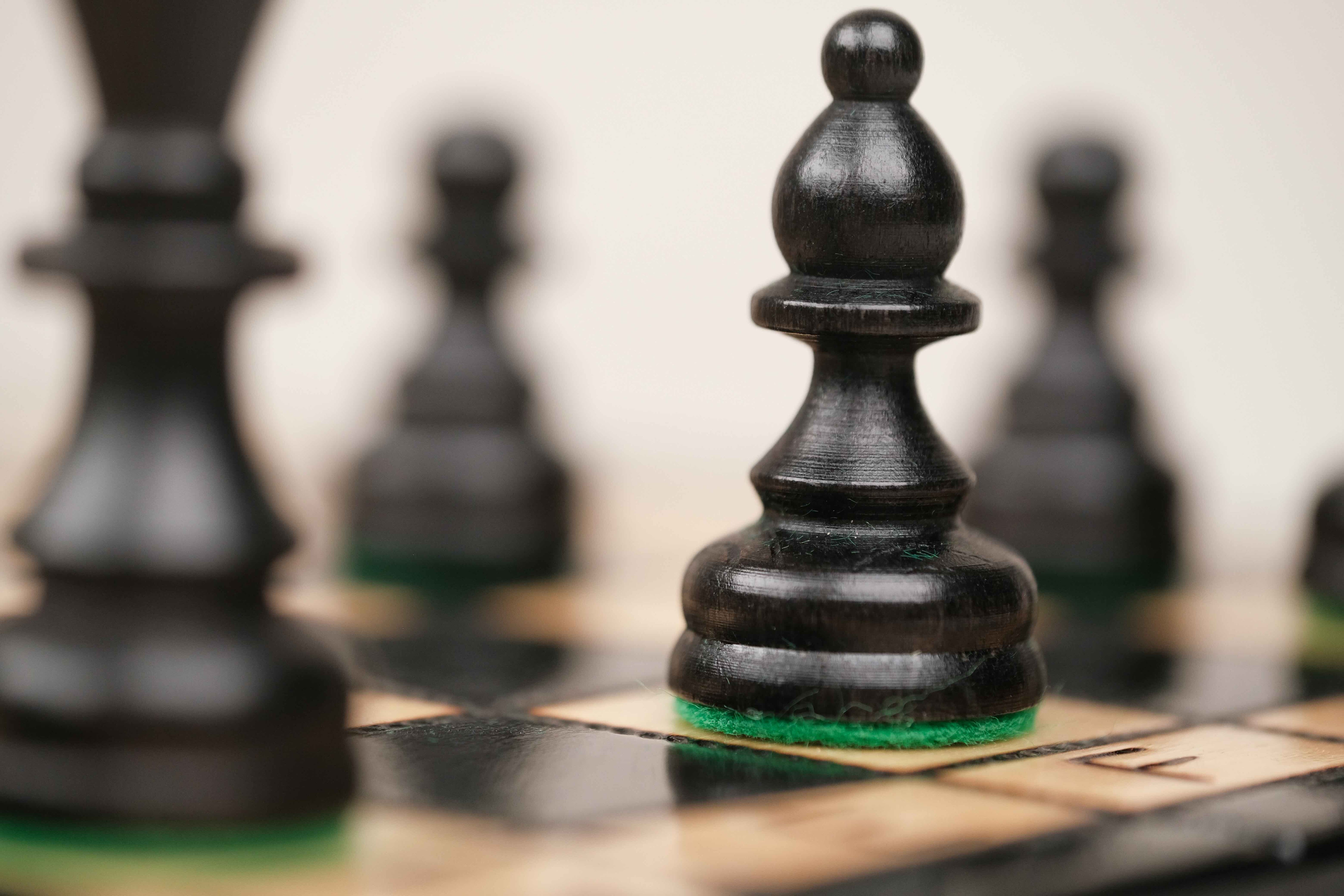 Pièces d’échecs noires sculptées avec base feutrée