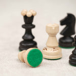 Détail de la feutrine verte sous une pièce d’échecs en bois