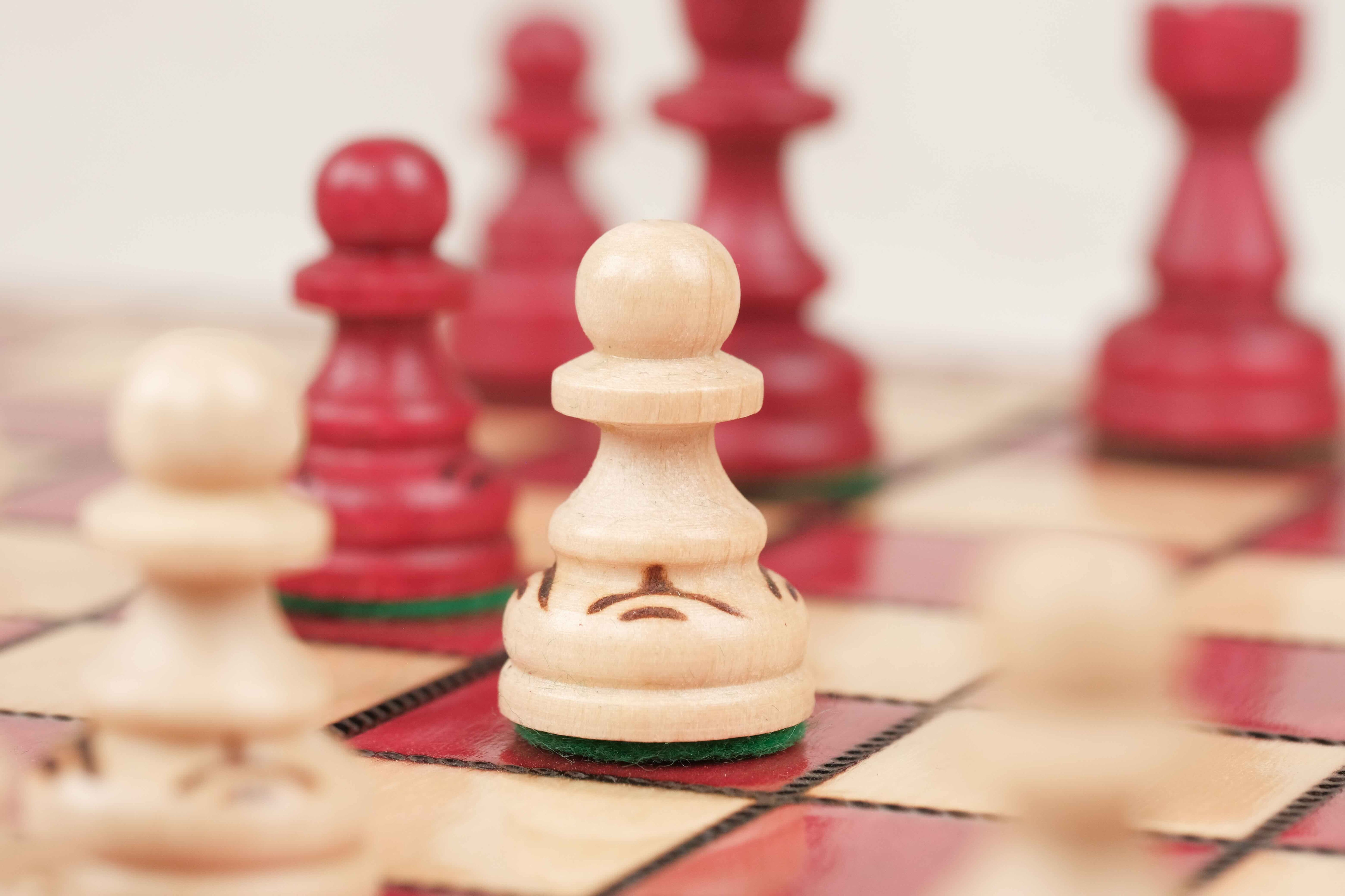 Pions et pièces d’échecs en bois blanc et rouge sculptés