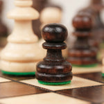 Pion d’échecs marron sur plateau en bois clair et foncé