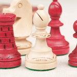 Zoom des pièces d’échecs rouge et beige sculptées en bois