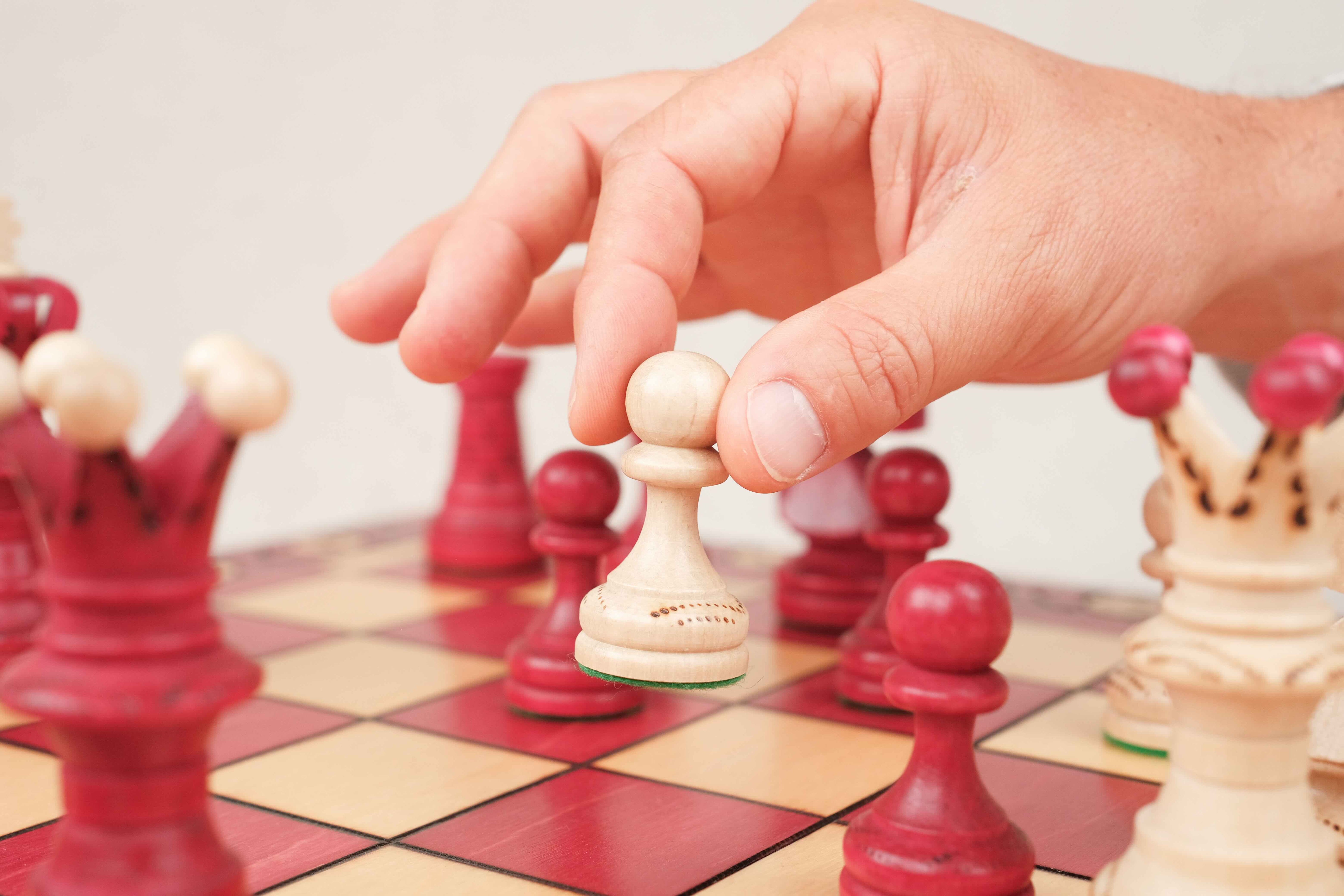 Joueur en train de jouer une partie de jeu d'échecs rouge Xl en bois - Jeux Faugère