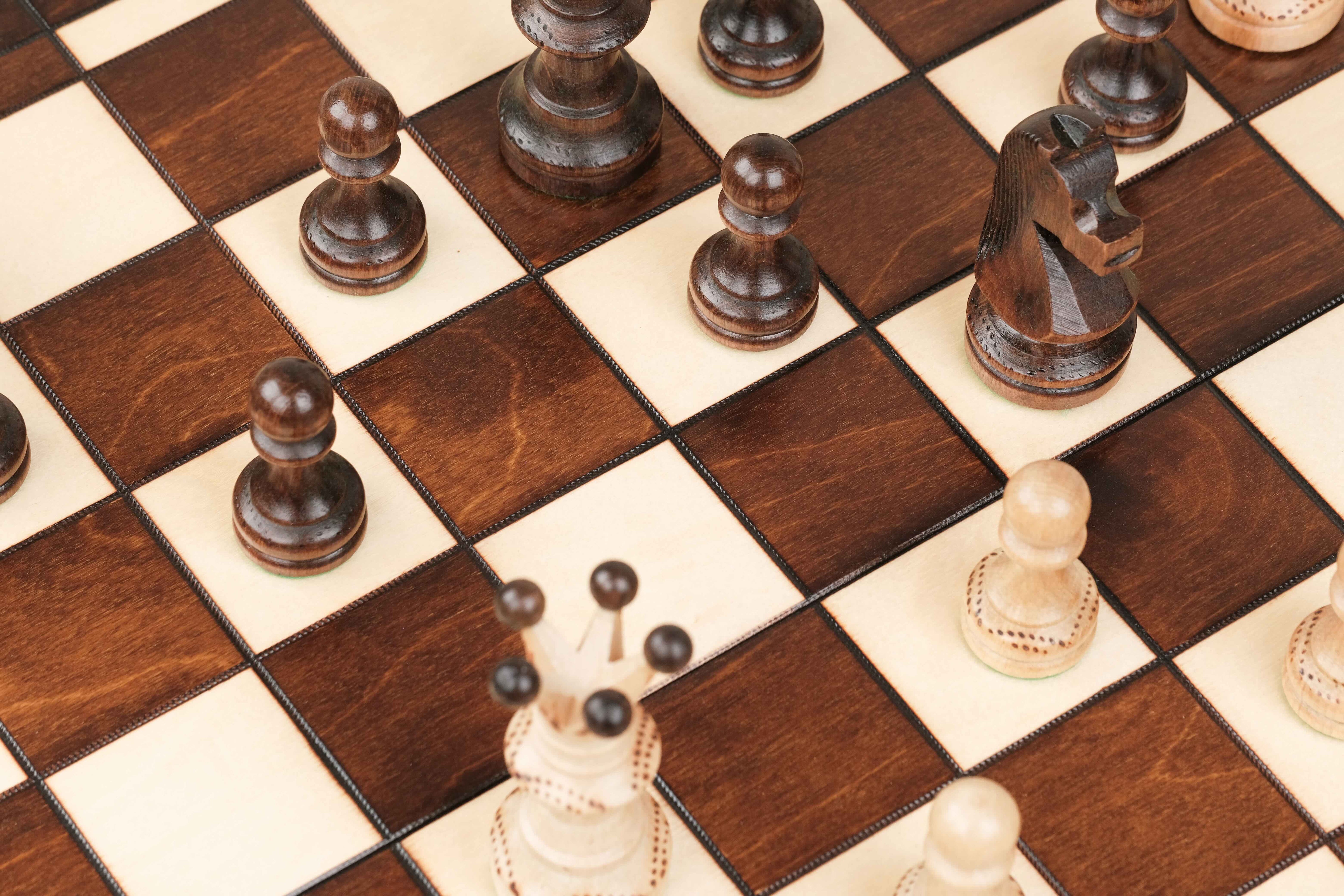 Détail de la gravure et de la teinte vernie du bois sur le damier du plateau