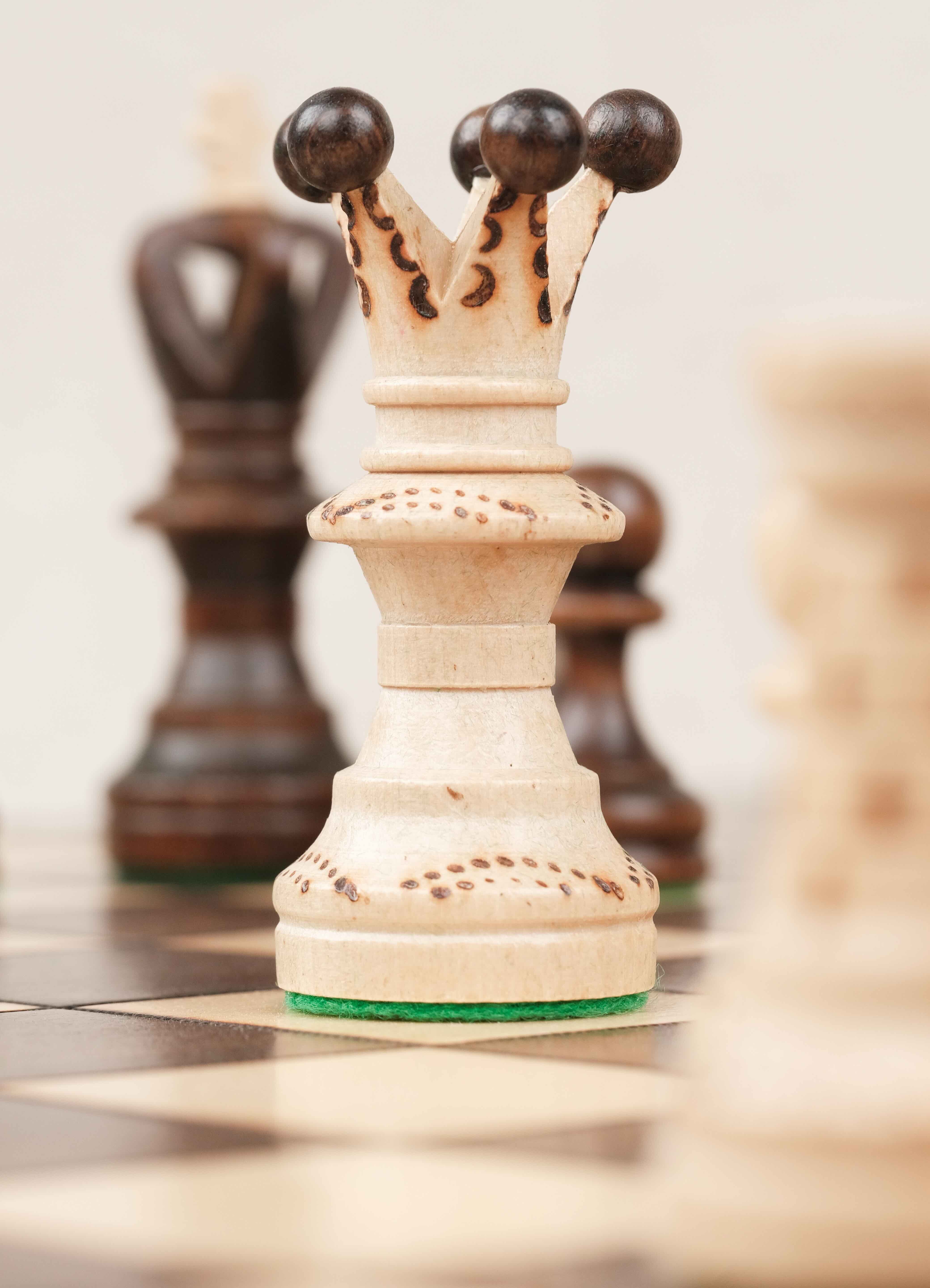 Détail d’une pièce blanc cassée (roi) sculptée sur l’échiquier