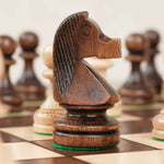 Zoom sur la pièce cavalier marron en bois positionné sur le plateau