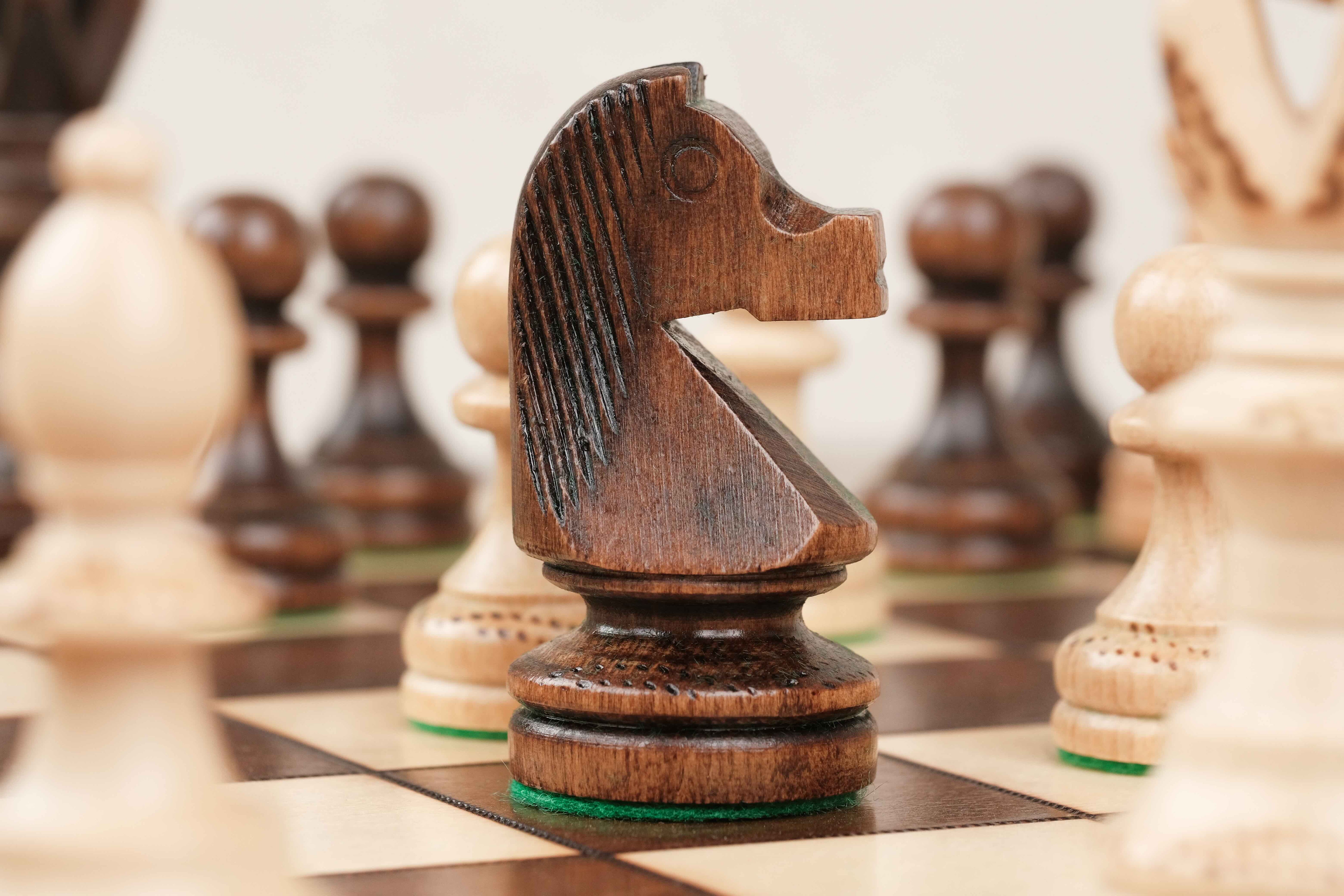 Zoom sur la pièce cavalier marron en bois positionné sur le plateau