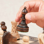 Main en train de déplacer une tour marron sur l’échiquier