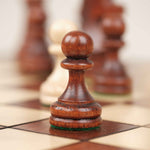 Gros plan sur un pion d’échecs marron clair sculpté en bois