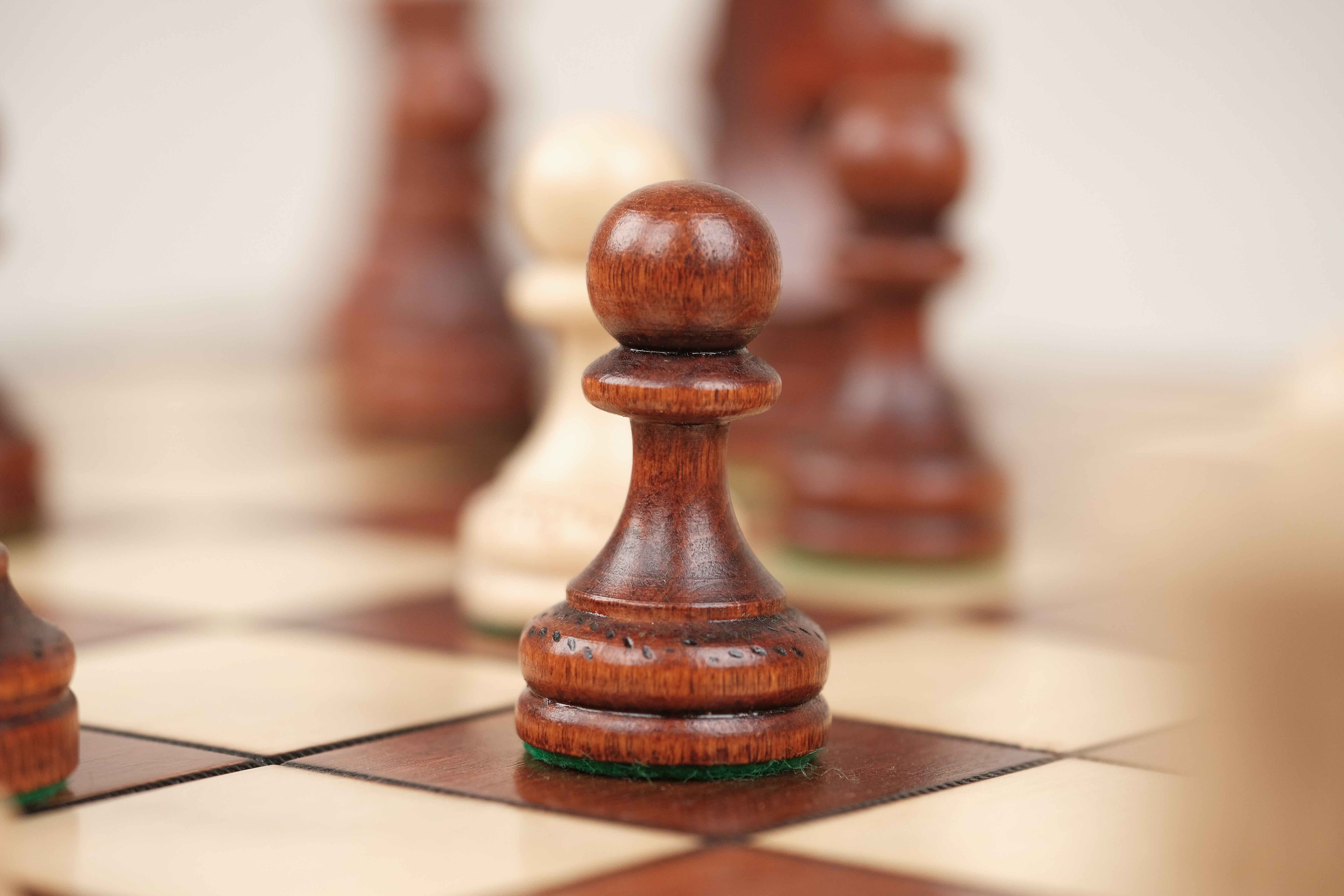 Gros plan sur un pion d’échecs marron clair sculpté en bois