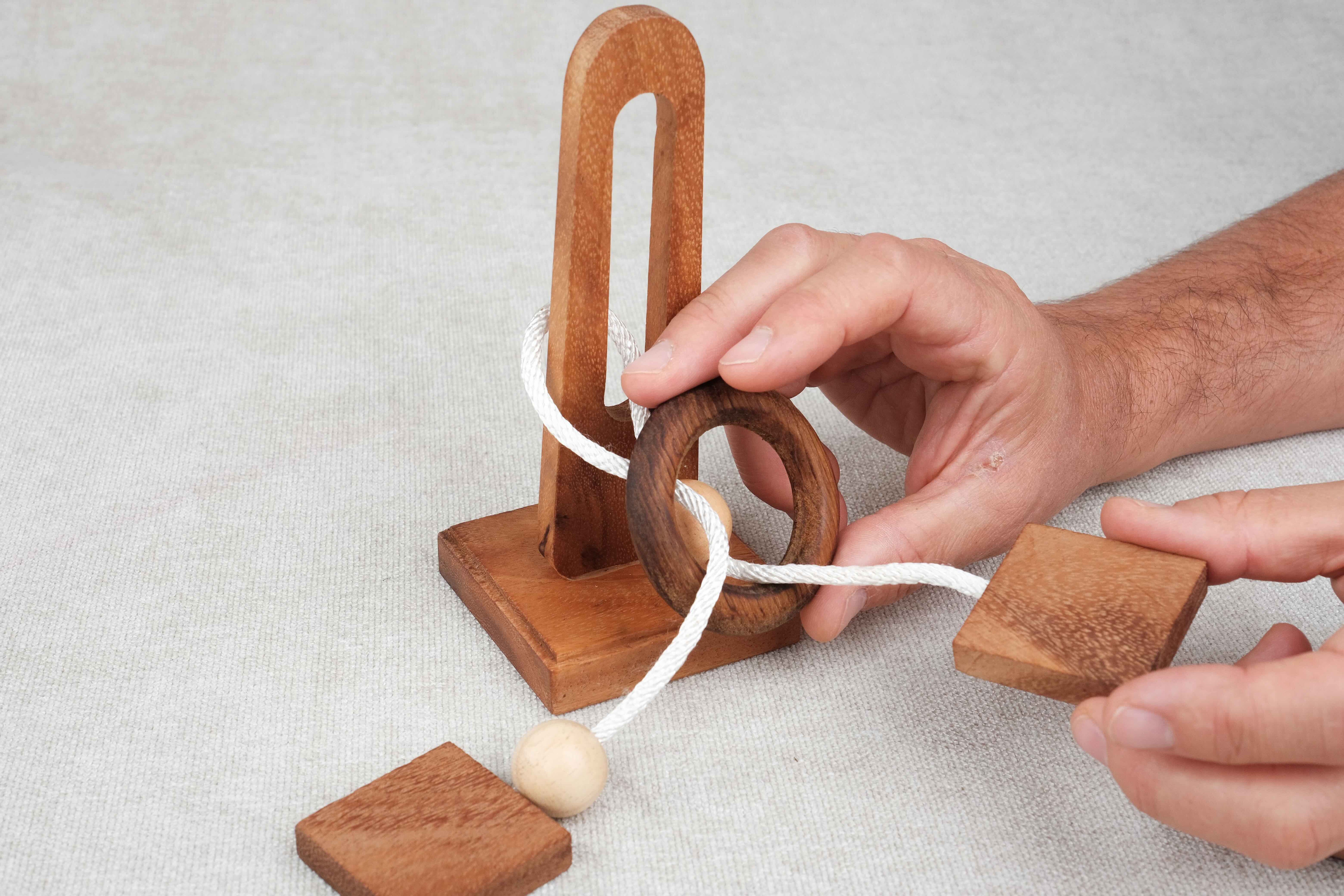 Joueur essayant de libérer l’anneau du casse-tête en ficelle