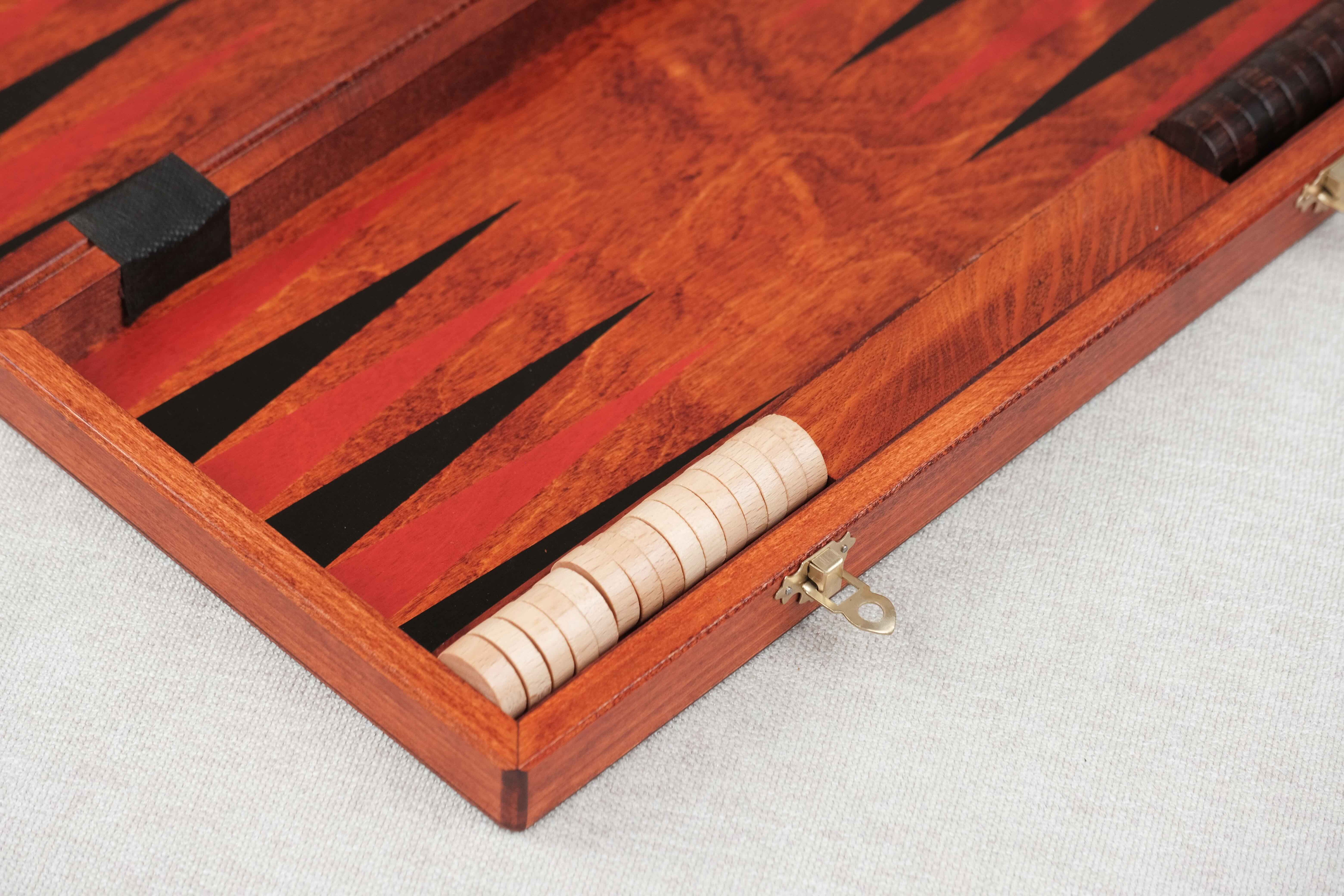 Pions noirs et clairs alignés dans le coffret de Backgammon