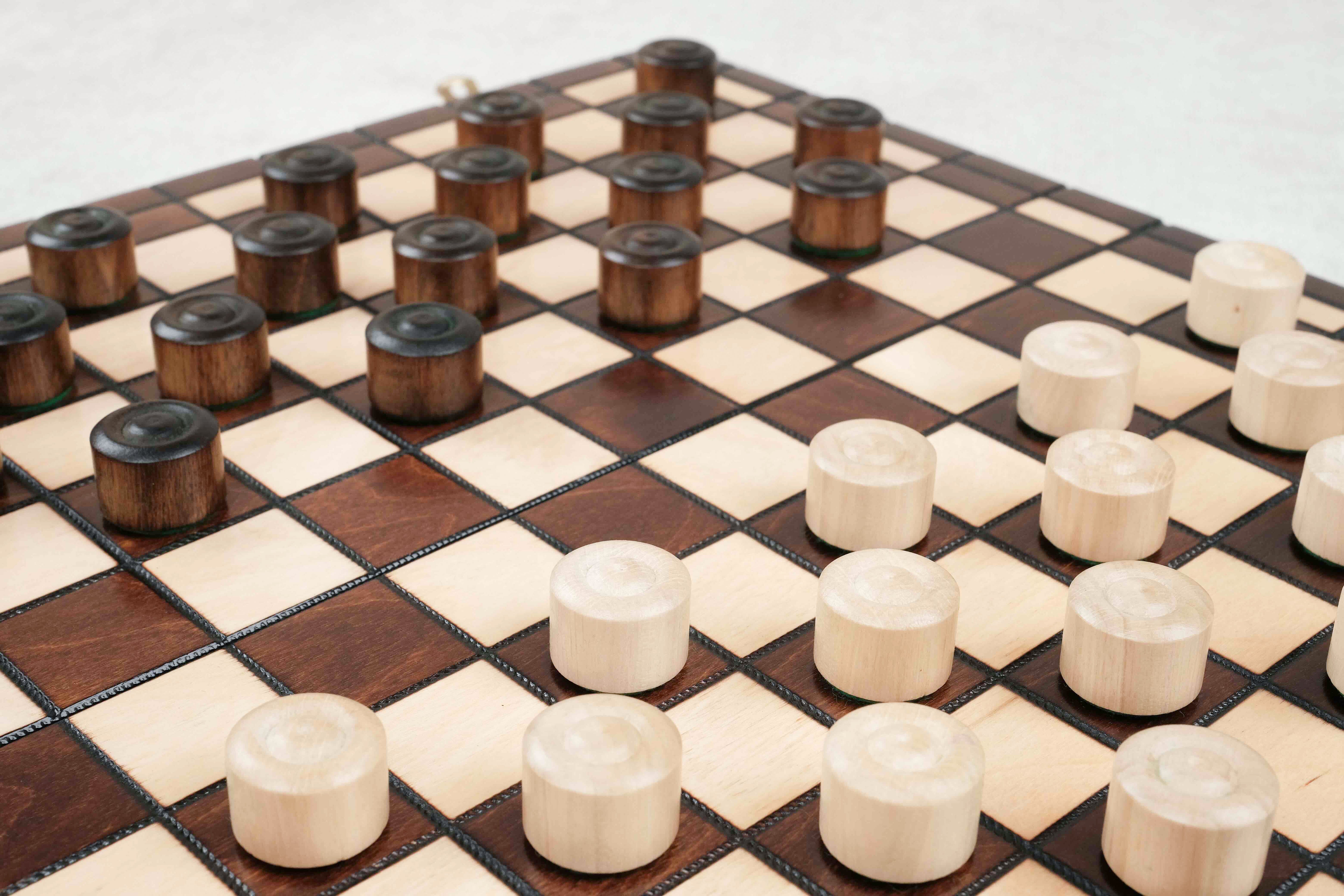 Détail du jeu de dames en bois marron avec cases naturelles et foncées