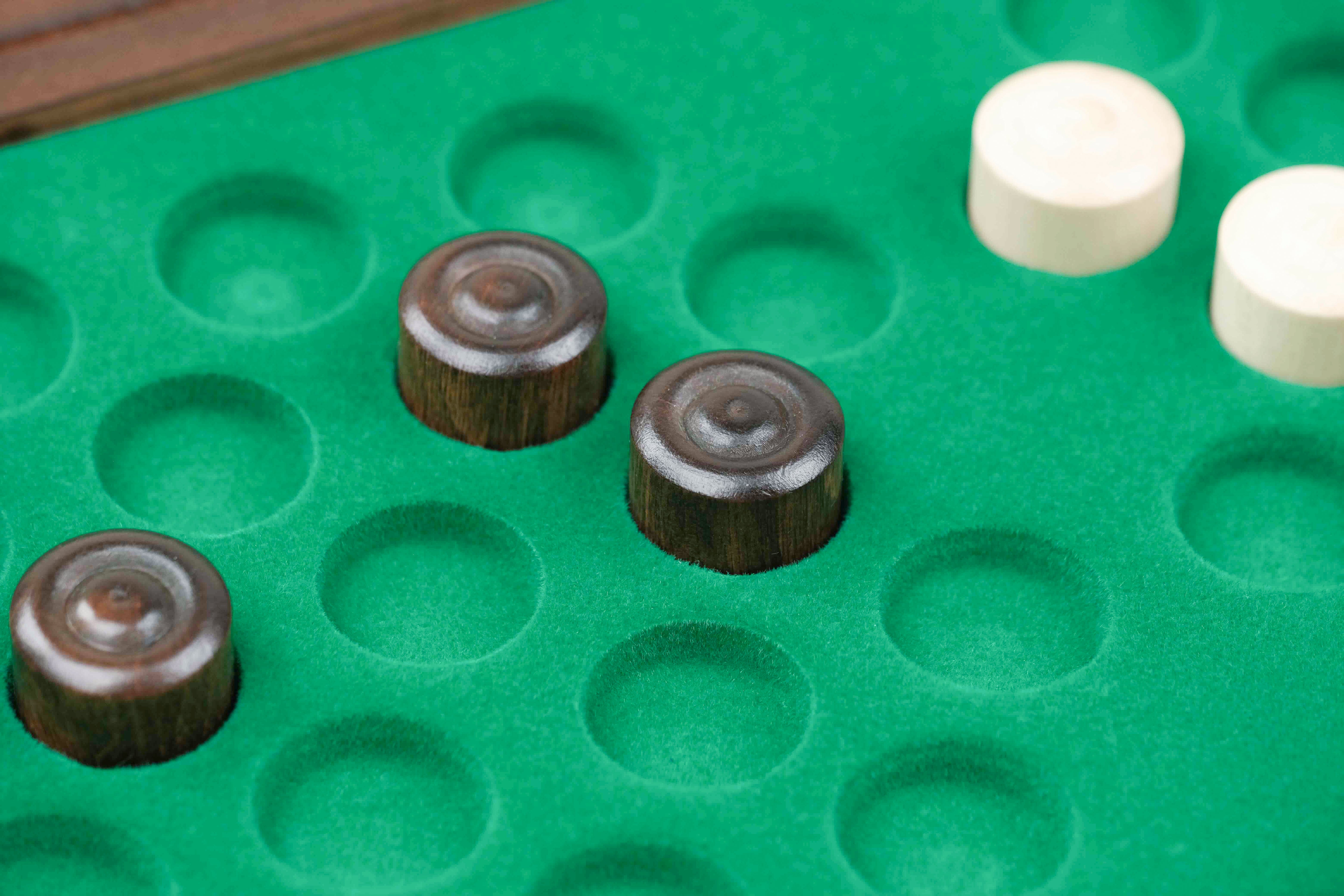 Rangement feutré vert avec pions de dames en bois