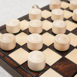 Zoom sur les pions de dames en bois clair et foncé