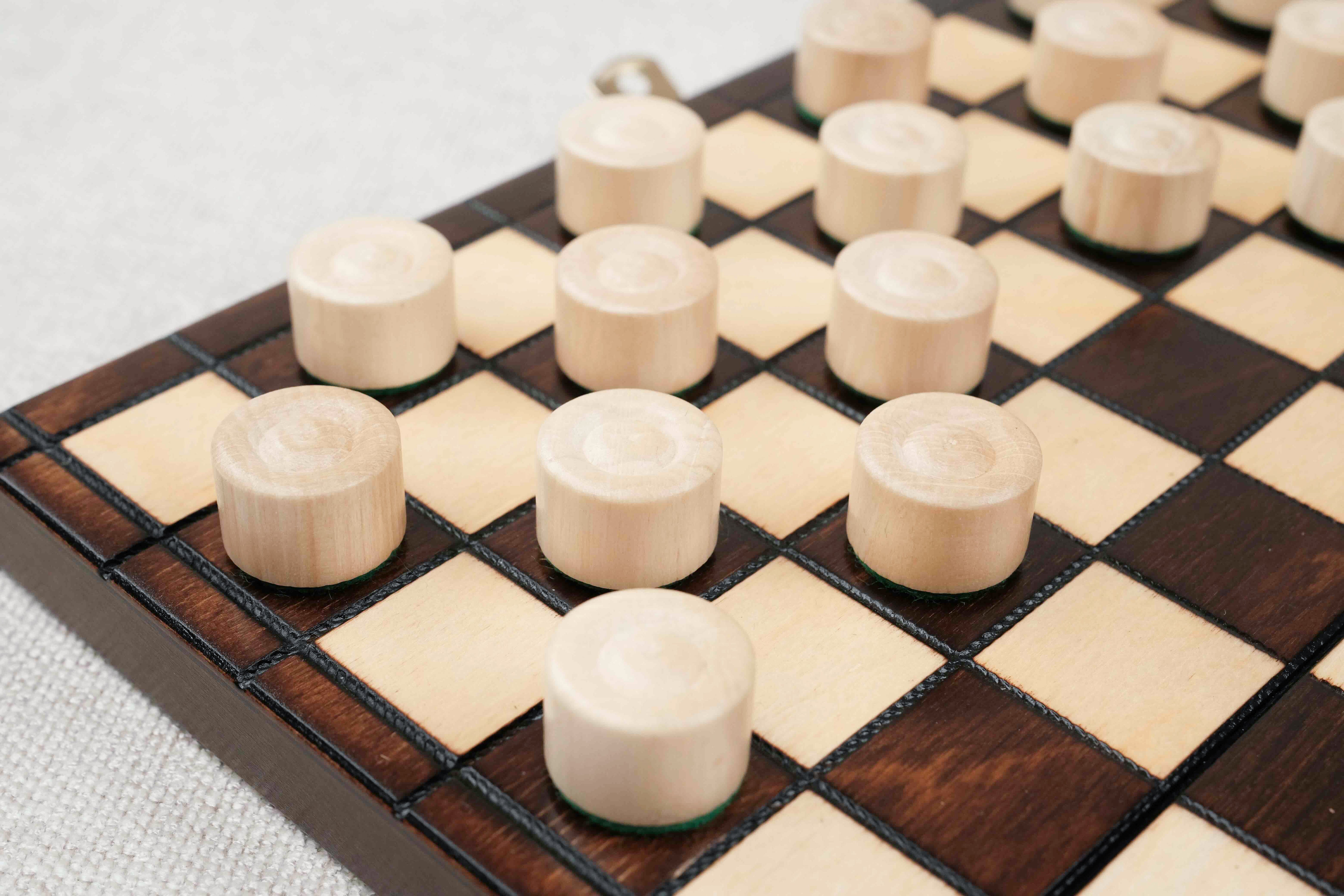 Zoom sur les pions de dames en bois clair et foncé