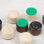 Zoom sur les pions de dames en bois clair et foncé et bases feutrine