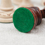 Pièce d’échecs marron clair avec base feutrée verte pour un confort de jeu optimal