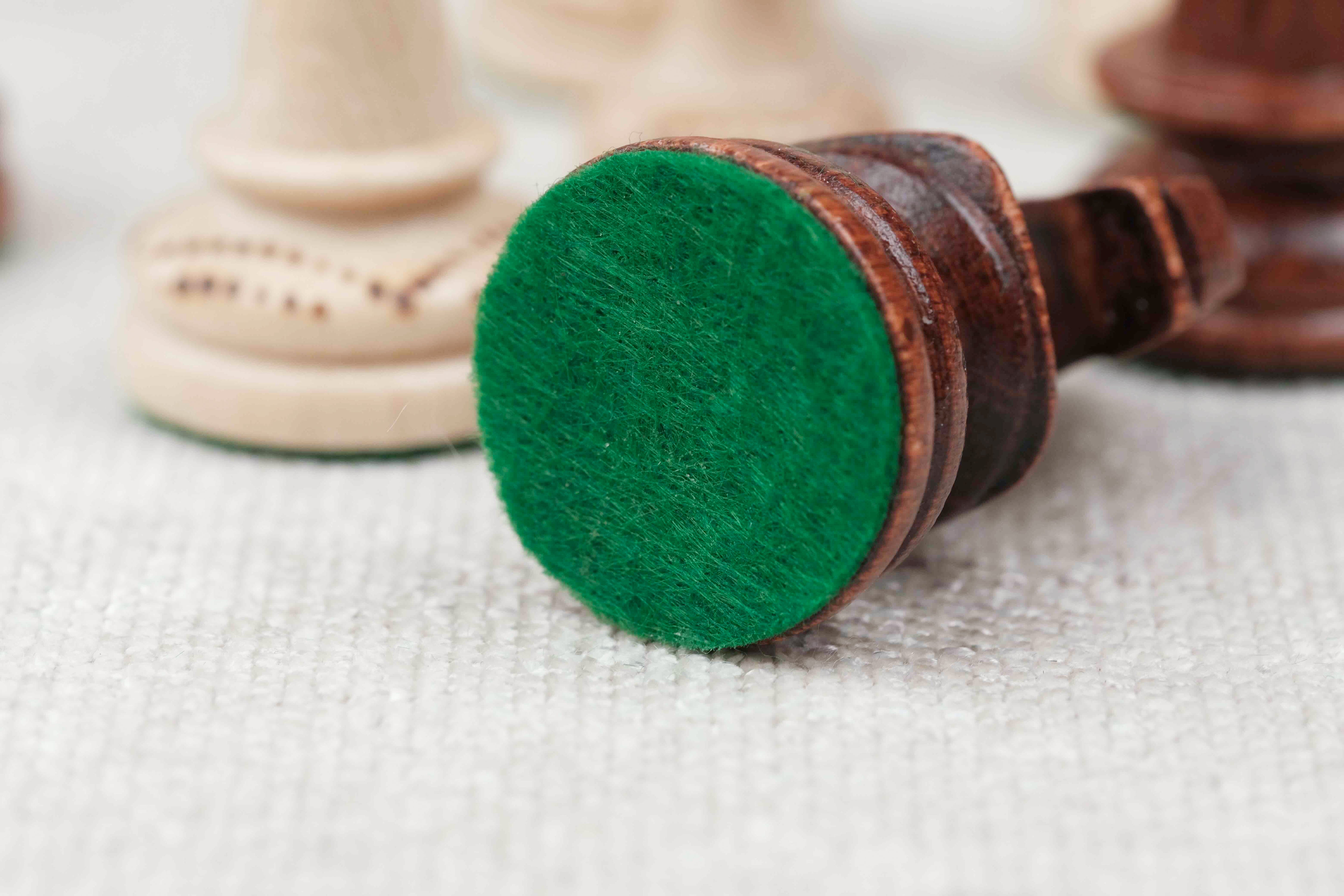 Pièce d’échecs marron clair avec base feutrée verte pour un confort de jeu optimal