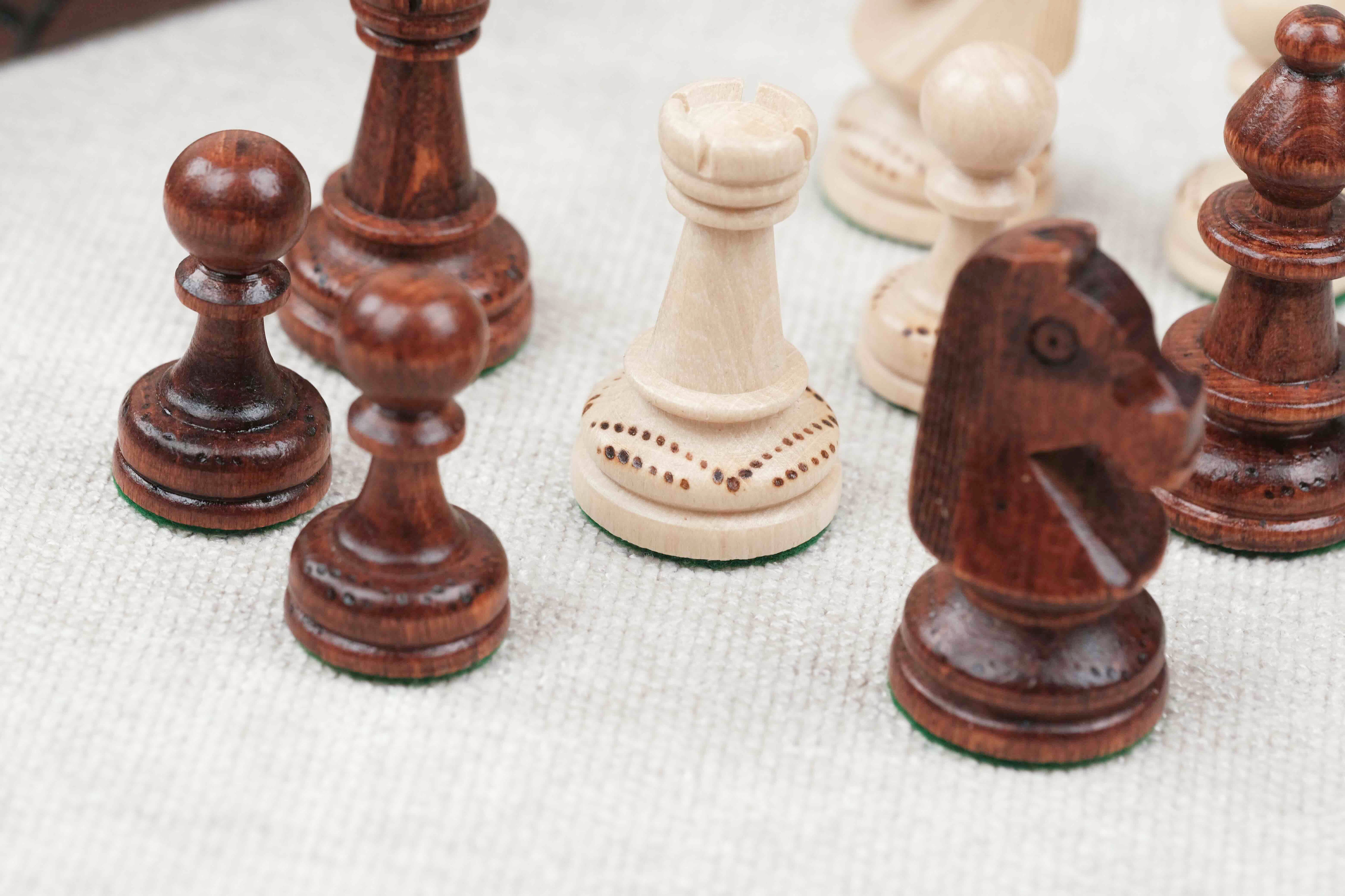 Pièces d’échecs blanche et marron clair en bois avec détails sculptés et gravés