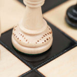 Détails gravure et pièces du plateau d’échecs en bois noir et naturel, grand format L