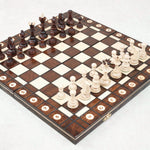 Plateau d'échec en bois foncé ouvert avec pièces en position de jeu