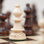 Détail d’une pièce blanche sculptée sur l’échiquier