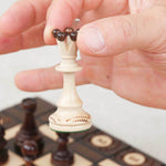 Main tenant une pièce au-dessus de l’échiquier