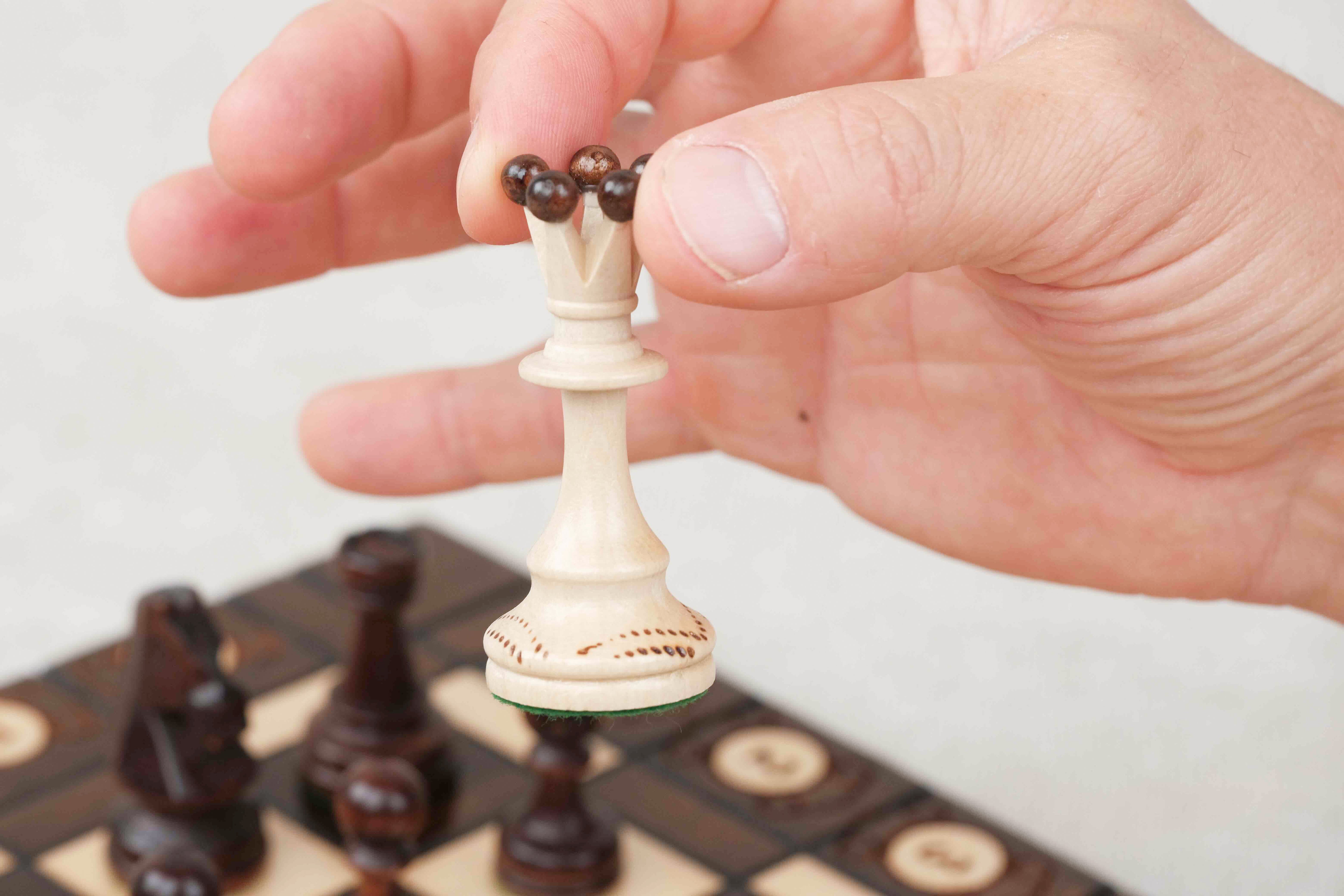 Main tenant une pièce au-dessus de l’échiquier