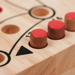 Détails des pions rouge en acacia placés dans les trous gravés du plateau Jeu de tock (toc) L clair en hévea