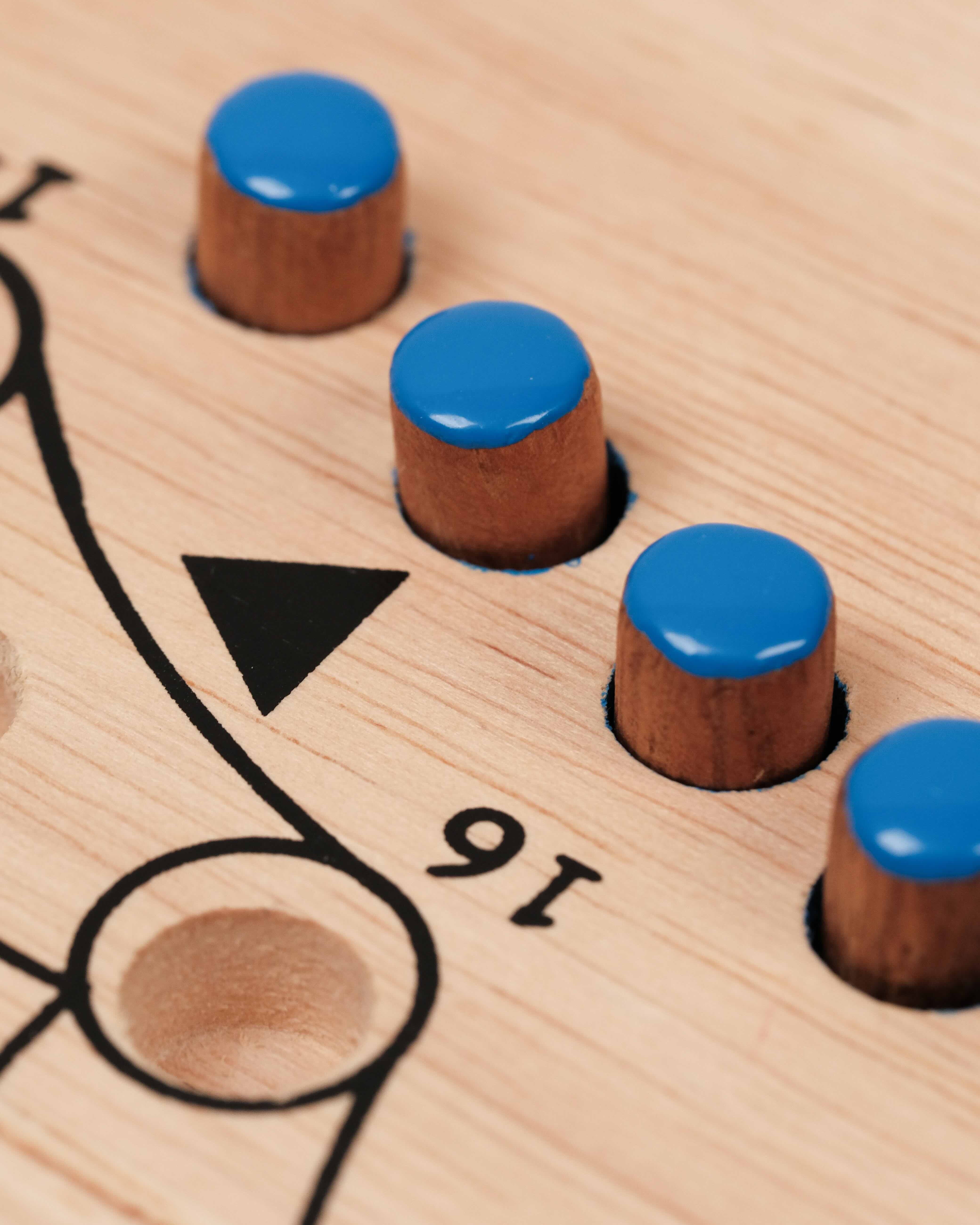 Détail des cases gravées avec pions bleu inserés sur le plateau Tock XL clair