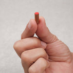 main tenant un pion rouge en acacia en bois