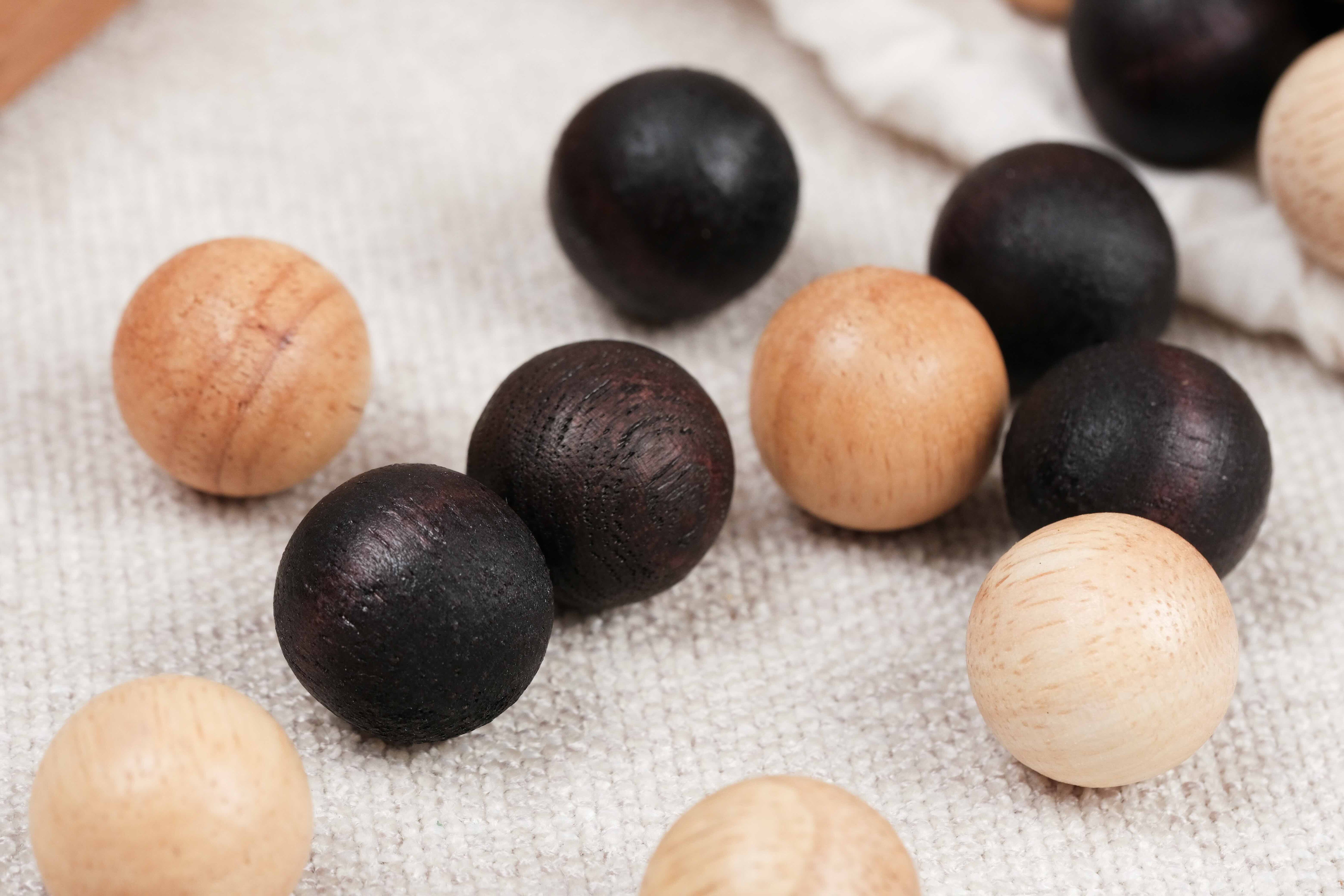 Billes en bois claires et foncées du jeu Fanorona