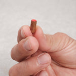 Pion rouge en bois tenu entre les doigts