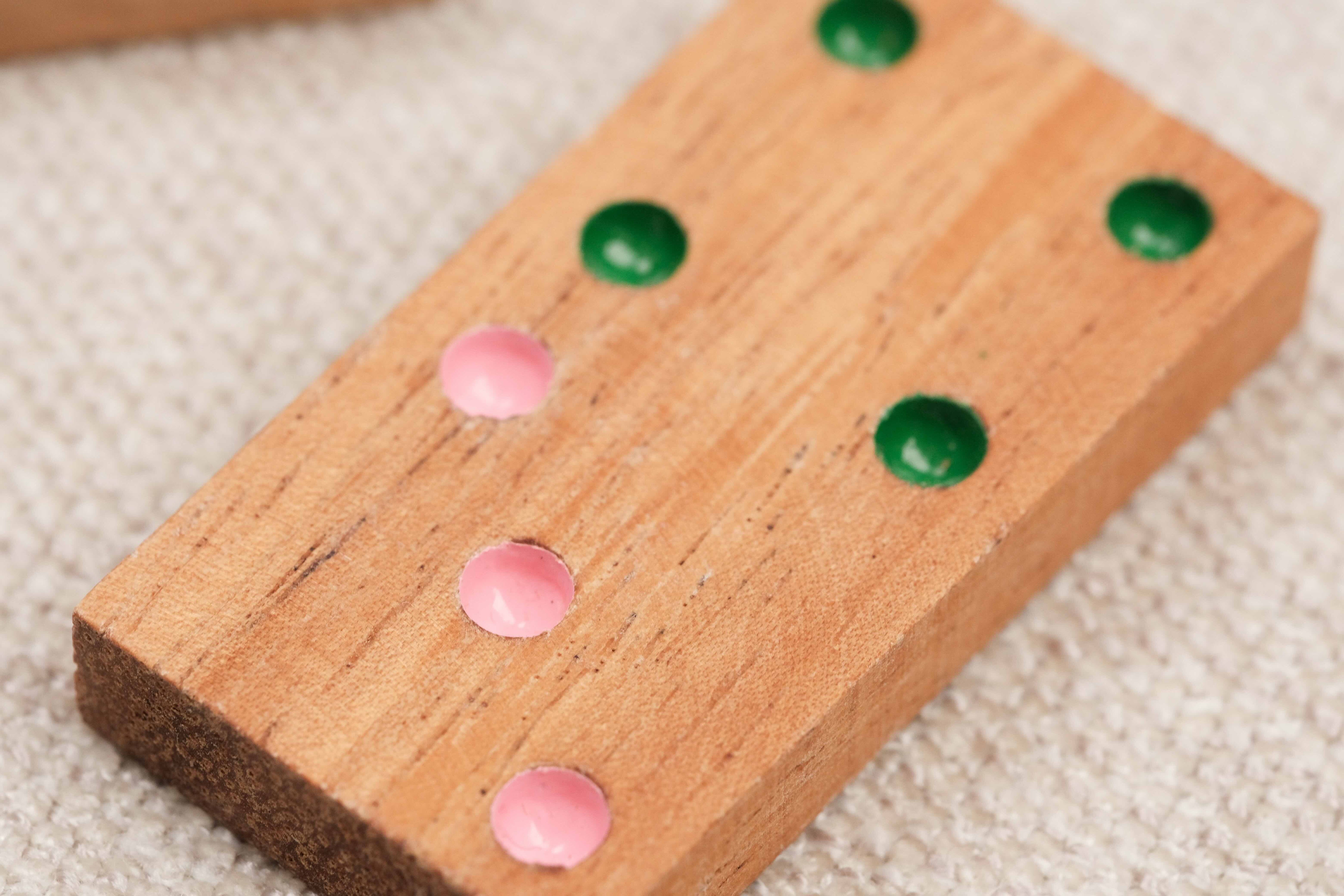 Gros plan sur une pièce de domino en bois avec points colorés