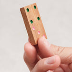 Pièce de domino en bois sérigraphié tenue en main