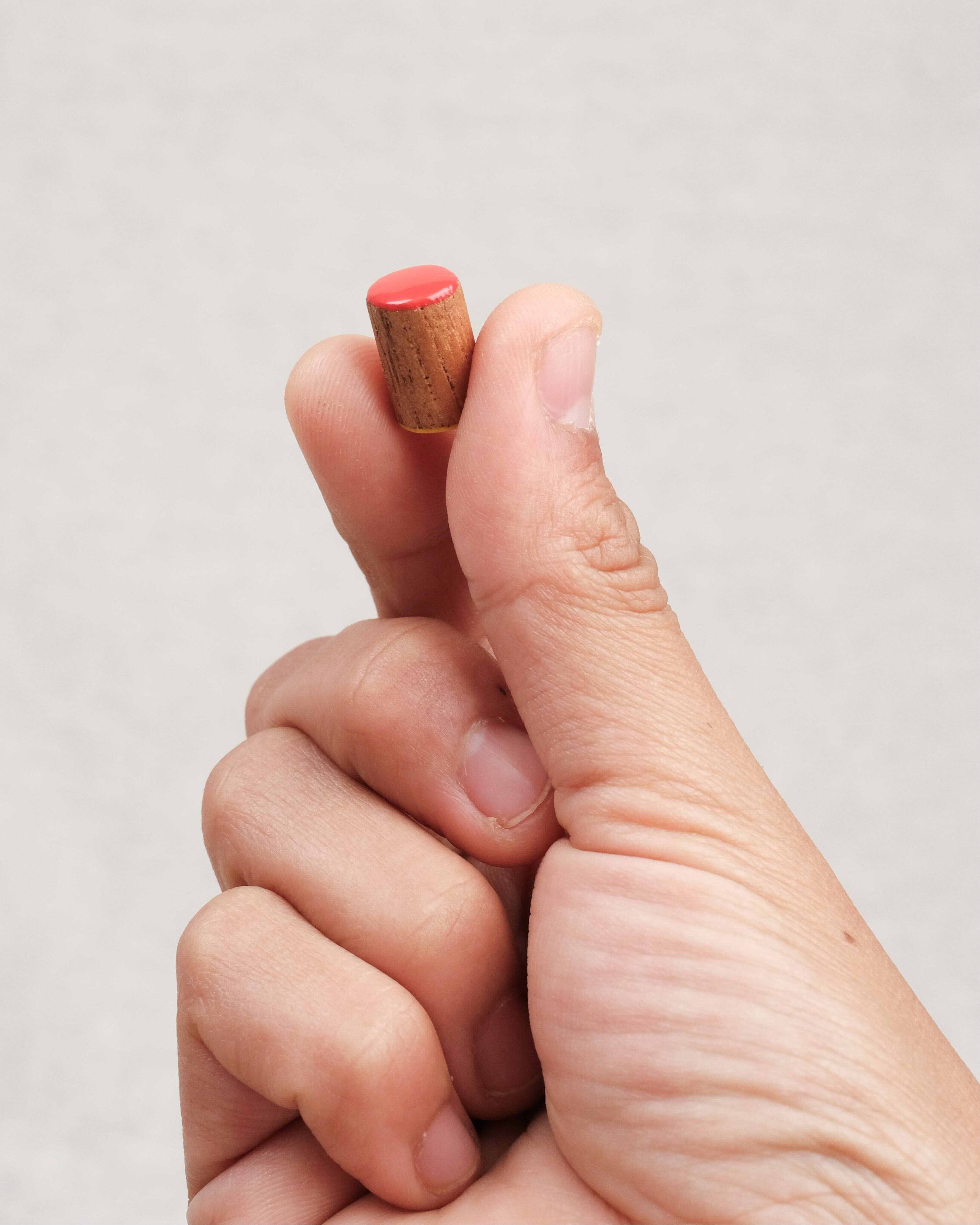 Main tenant un pion de dames sérigraphié