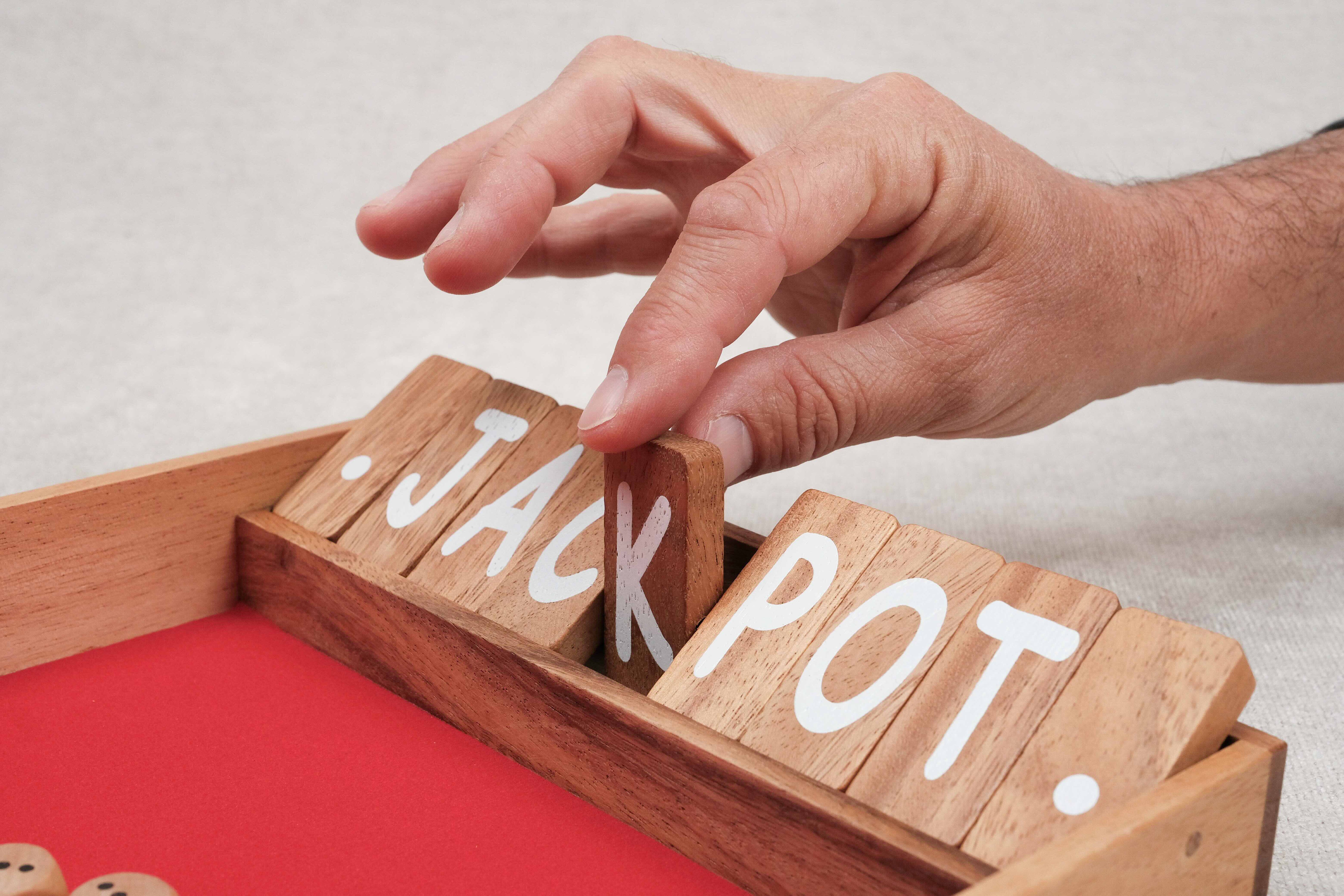 Main fermant une case du jeu Ferme la Boîte.