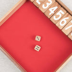 Jeu Ferme la Boîte en bois avec dés lancés sur le tapis.