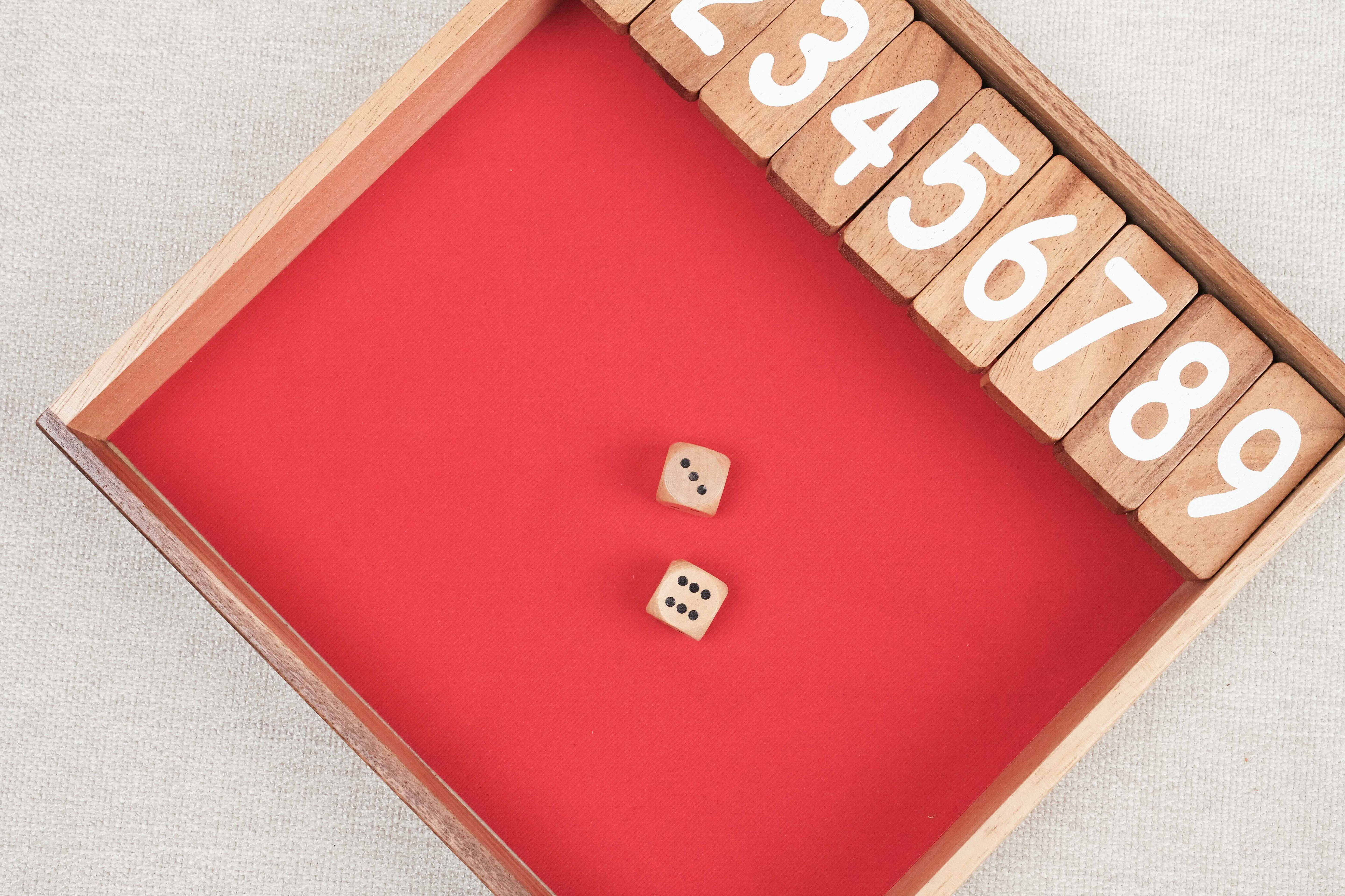 Jeu Ferme la Boîte en bois avec dés lancés sur le tapis.