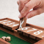 Main qui ferme une case numérotée sur le jeu Ferme la Boîte petit modèle.