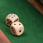 Gros plan sur deux dés en bois posés sur le plateau.