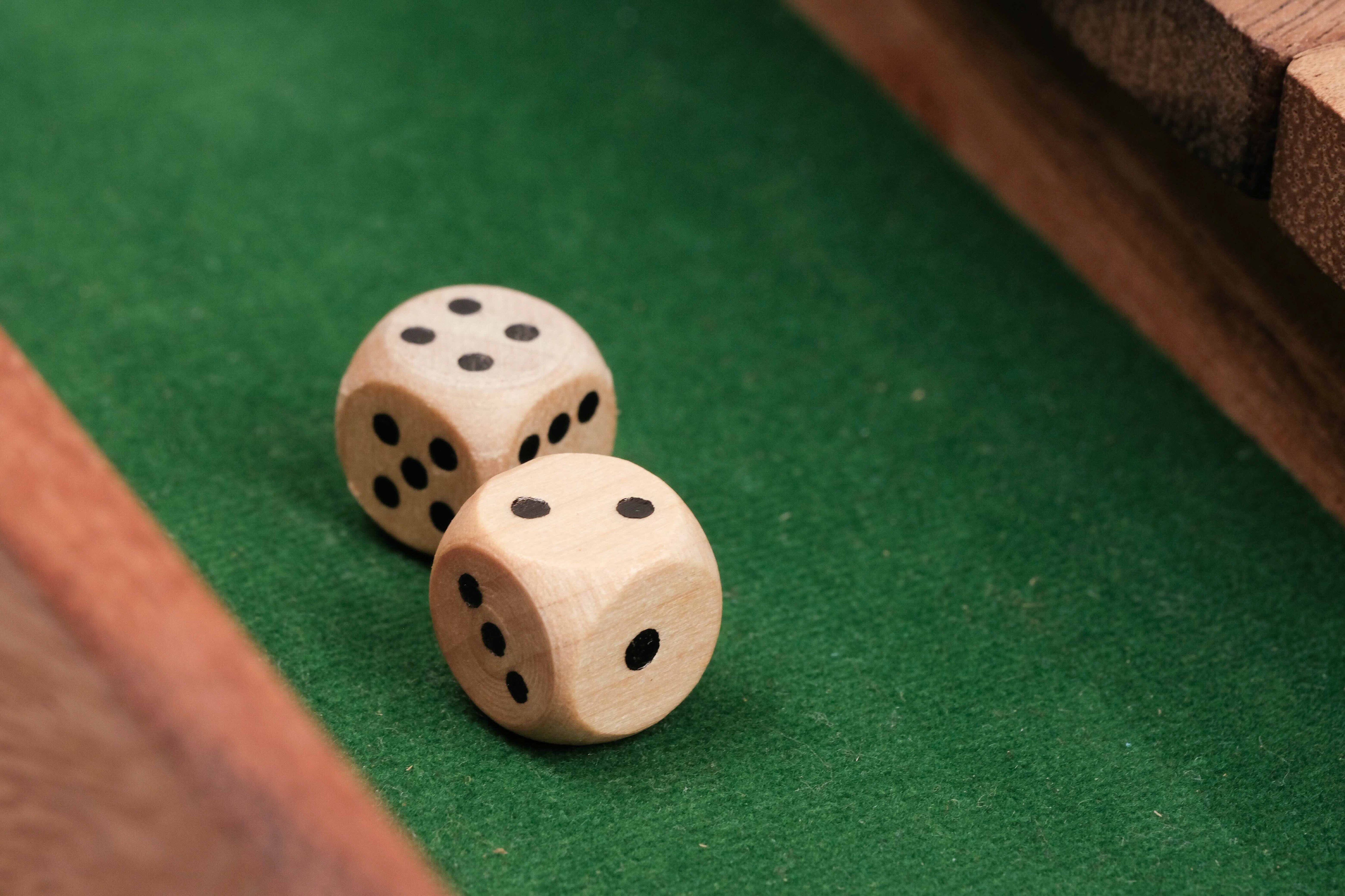 Gros plan sur deux dés en bois posés sur le plateau.